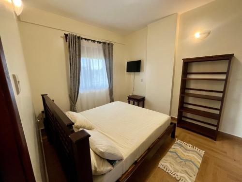 a small bedroom with a bed and a window at Ibis Stays in Naziba