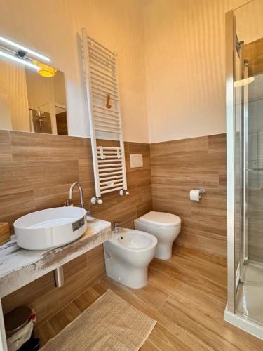 a bathroom with a sink and a toilet and a mirror at Petali Rosa - Dimora Antica Roma in Polignano a Mare