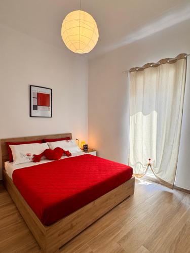 a bedroom with a red bed with a red teddy bear on it at Petali Rosa - Dimora Antica Roma in Polignano a Mare
