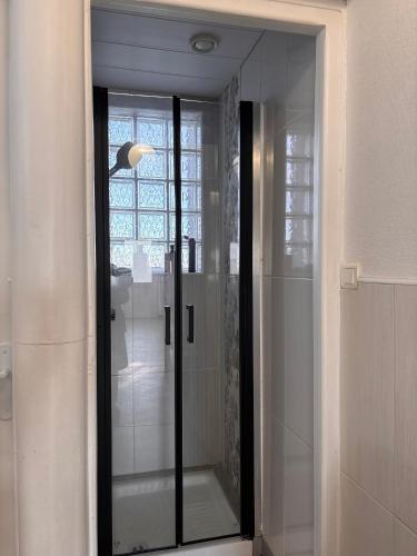 a glass shower in a bathroom with a mirror at Gîte Les Mirabelliers à Morville Hébergement cosy in Morville