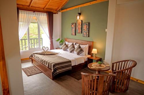 a bedroom with a bed with a window and a table at The Mount View Single Tree Hotel in Nuwara Eliya