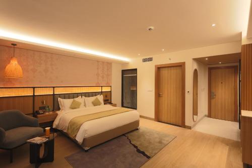 a hotel room with a bed and a chair at Hotel Palacio Paltan Bazaar in Guwahati