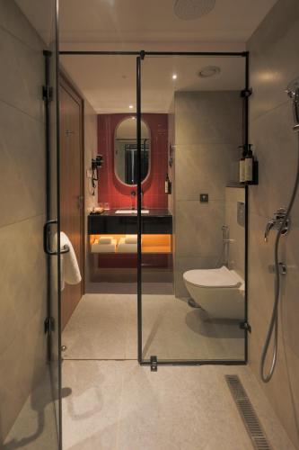 a bathroom with a shower with a toilet and a sink at Hotel Palacio Paltan Bazaar in Guwahati