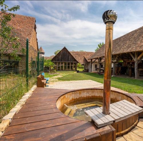 a wooden deck with a fountain in a yard at Șura din Seleuș - Seleuș Barn - Idyllic Countryside M Museum House in Sighişoara