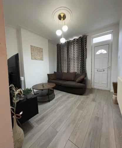 a living room with a couch and a table at F2S SERVICED APARTMENTS 2Bedroom Terrace house with Free Wifi Netflix Suitable for Contractors walking distance to Train station in Derby