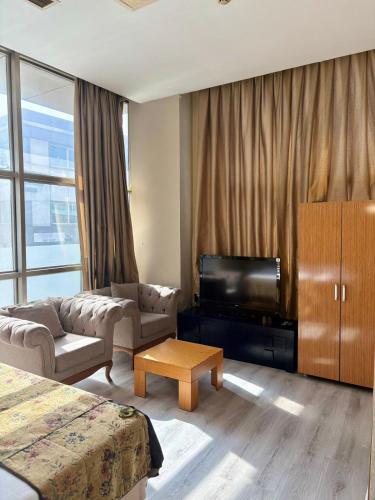 ein Wohnzimmer mit Sofa, Fernseher und einem Zimmer in der Unterkunft ferhane hotel in Adana
