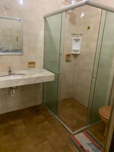 a bathroom with a glass shower and a sink at Pousada Malu in Fortaleza