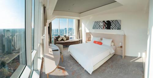 a bedroom with a white bed and a couch at HARRIS Suites fx Sudirman in Jakarta