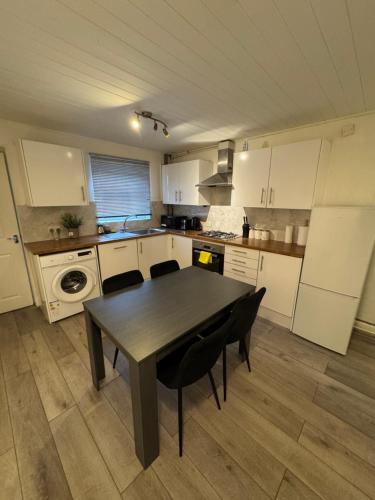 a kitchen with a table and chairs in it at F2S SERVICED APARTMENTS 2Bedroom Terrace house with Free Wifi Netflix Suitable for Contractors walking distance to Train station in Derby