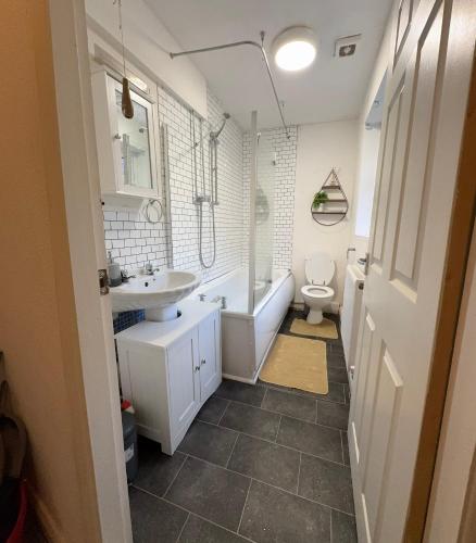 a bathroom with a tub and a sink and a toilet at F2S SERVICED APARTMENTS 2Bedroom Terrace house with Free Wifi Netflix Suitable for Contractors walking distance to Train station in Derby
