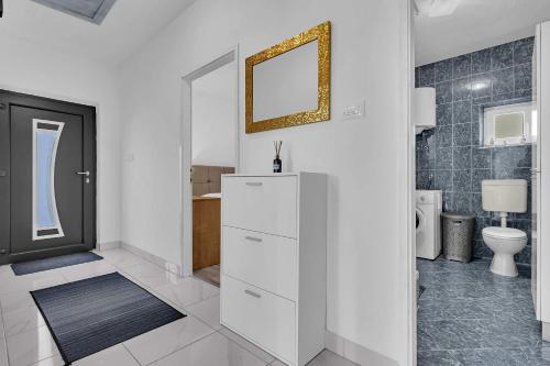 a white bathroom with a toilet and a mirror at Apartment Green Valley in Imotski
