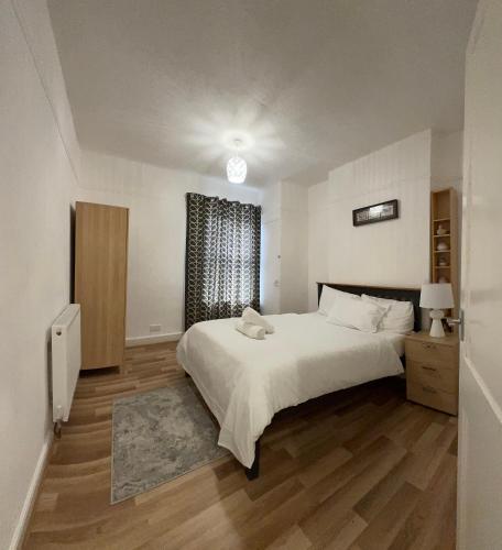 a bedroom with a large white bed and a window at F2S SERVICED APARTMENTS 2Bedroom Terrace house with Free Wifi Netflix Suitable for Contractors walking distance to Train station in Derby