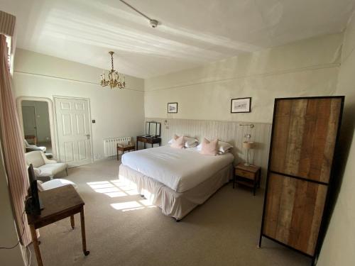 a bedroom with a white bed and a chair at The Cavendish Arms in Cartmel