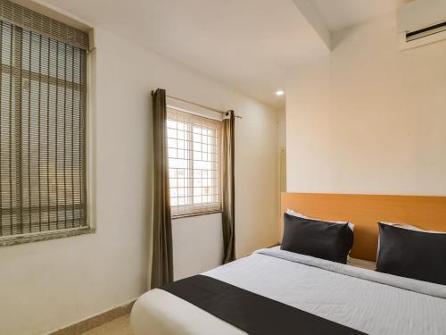 a bedroom with a bed and a window at Super Townhouse Qualia Prime in Hyderabad