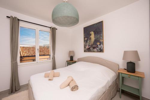 a bedroom with a white bed with a window at Appartement neuf et moderne à Grimaud - Fééries Provençales 212 in Grimaud