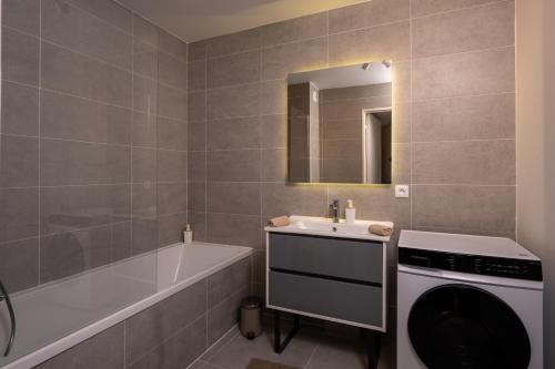 a bathroom with a tub sink and a washing machine at Appartement neuf et moderne à Grimaud - Fééries Provençales 212 in Grimaud