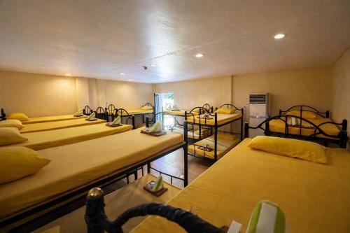 a room with a bunch of beds in it at Alta Cebu Resort Mactan powered by Cocotel in Mactan