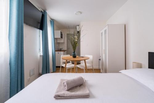 a bedroom with a white bed and a table at High Five - Chambre Calme Sur Les Ramblas in Toulouse