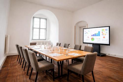 a conference room with a long table and chairs and a screen at Die Burg - Kurfürstlich Flämisch in Bad Belzig