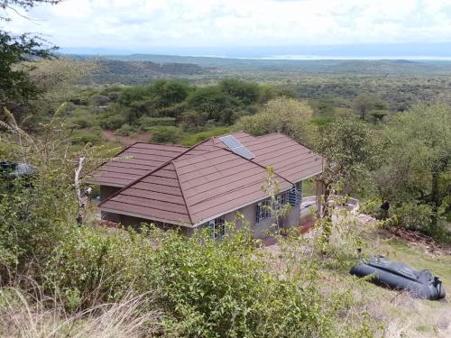 a house with a roof on top of a field at Footprint Baringo in Marigat