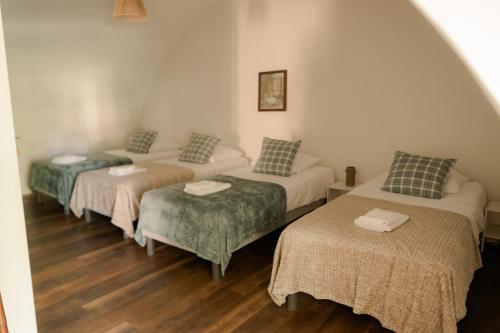 three beds in a room with wood floors at ABBAYE DE BLANCHELANDE in Neufmesnil