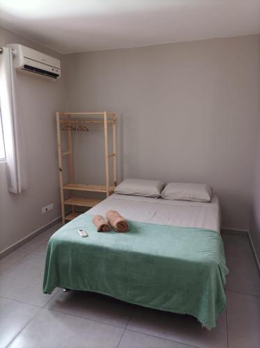 a bedroom with a bed with two slippers on it at Casa da Simonia in Foz do Iguaçu