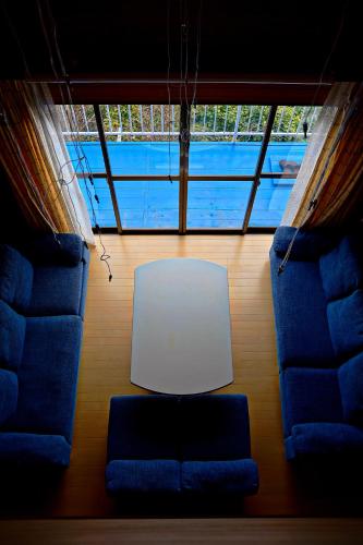 a living room with two chairs and a white table at 【全室オーシャンビュー 海堪能 抜群景色】貸切一軒家 WIFI付/カラオケ無料/最大８名/無料駐車場 in Okawa