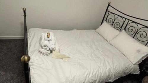 ein weißes Bett mit einer Statue von zwei Personen darauf in der Unterkunft SAMAz in Manchester