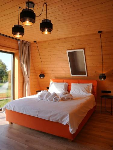 a bedroom with a bed in a wooden wall at Vino Chalets Bran in Sohodol