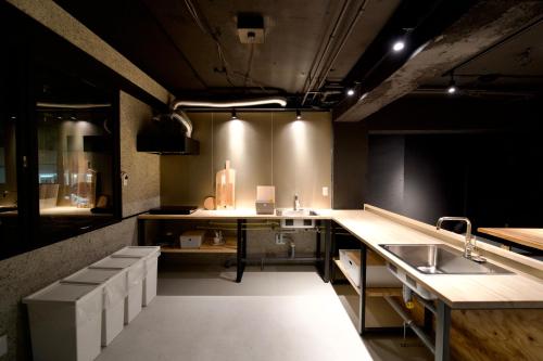 a large kitchen with a counter and a sink at Hotel KOTO in Sapporo