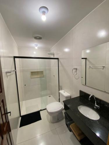 a bathroom with a shower and a toilet and a sink at Casa da Simonia in Foz do Iguaçu