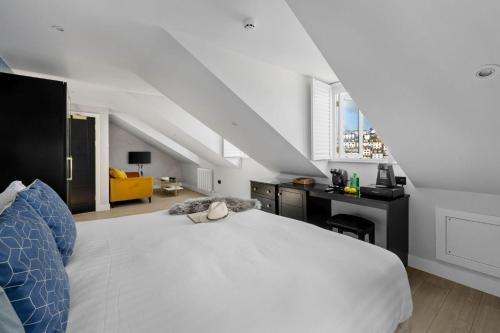 a bedroom with a large white bed and a desk at Provident Suite - Free Wi-Fi - Sea View in Brixham