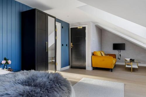 a living room with a yellow chair and blue walls at Provident Suite - Free Wi-Fi - Sea View in Brixham