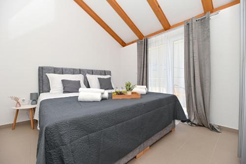 a bedroom with a large bed and a window at apartmani sukošan in Sukošan