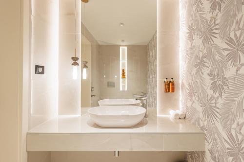 ein weißes Badezimmer mit Waschbecken und Spiegel in der Unterkunft Hotel Osijek in Osijek