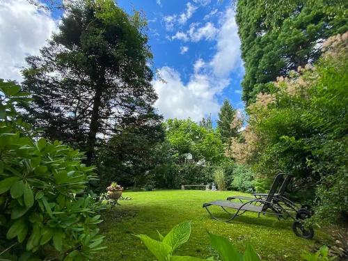 a park bench sitting in the middle of a field at Villa With Split-Level Architecture By Ammersee in Hechenwang