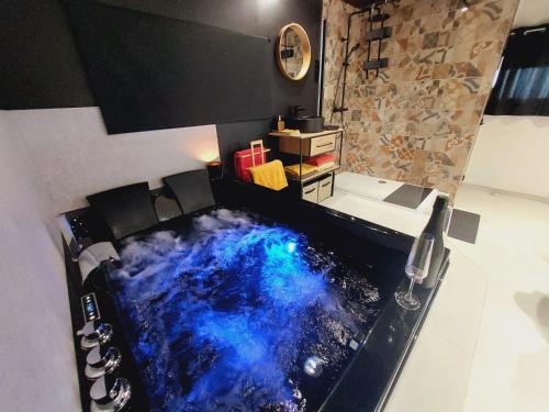 eine Badewanne mit blau-schwarzem Boden in der Unterkunft Le sandron in Marchin