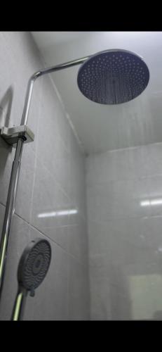a shower stall with a shower head and a shower head at Elite Apartment in Nizwa