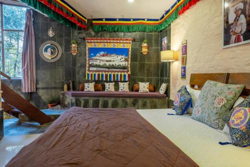 a bedroom with a large bed and a bench at Mud House Entire Cottage in Dharmsāla