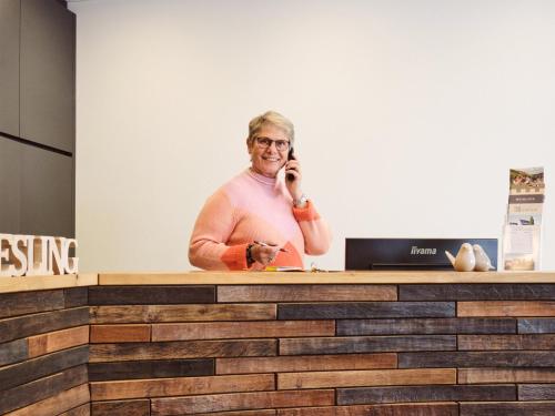 a woman talking on a cell phone at a counter at Ferienweingut-Liebfried in Nehren