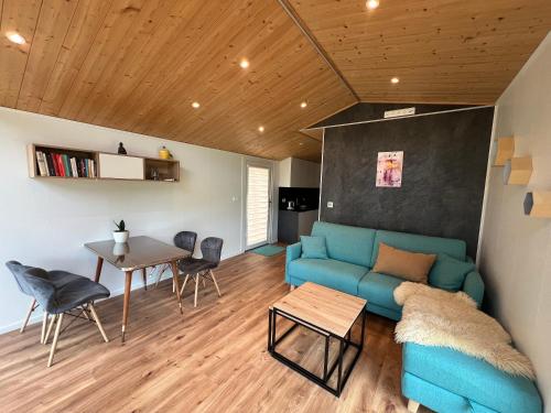 a living room with a blue couch and a table at Ferienhaus am See in Körba in Lebusa