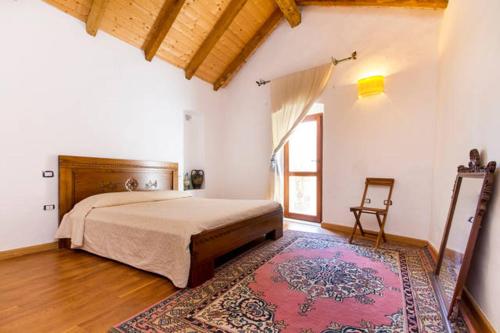サンタンティーオコにあるAuthentic Sardinian Homeのベッドルーム1室(大型ベッド1台、ラグ付)