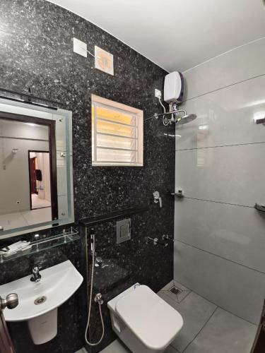 a bathroom with a toilet and a sink and a mirror at G10 & 12 - Sabari Enclave Premium One bedroom Apartment in Trivandrum