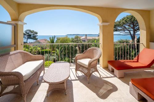 a porch with wicker chairs and a table at Best Western Premier Montfleuri in Sainte-Maxime