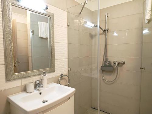 a bathroom with a sink and a glass shower at Sunshine Residence Silver Apartment in Hévíz