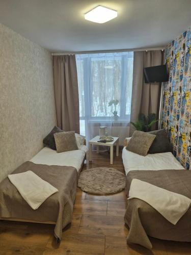 a room with two beds and a table and a window at Leśna Przystań in Iława