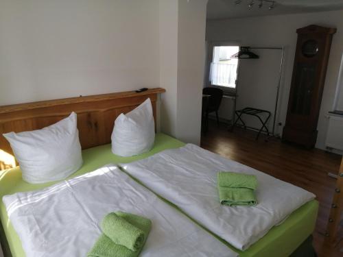 a bedroom with a bed with two green towels on it at Kastanienhof Lübben in Lübben