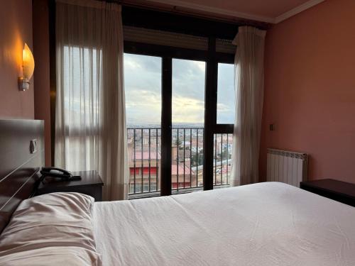a bedroom with a bed and a large window at Hotel Santa Teresa in Ávila