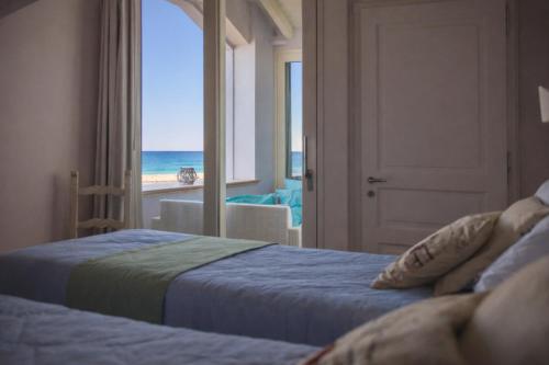 a bedroom with two beds and a view of the ocean at Villa Lilla sulla Spiaggia di San Vincenzo LUXURY in San Vincenzo
