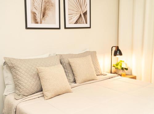 a bedroom with a white bed with pillows at Vinícola Villa Aurum in Corumbá de Goiás
